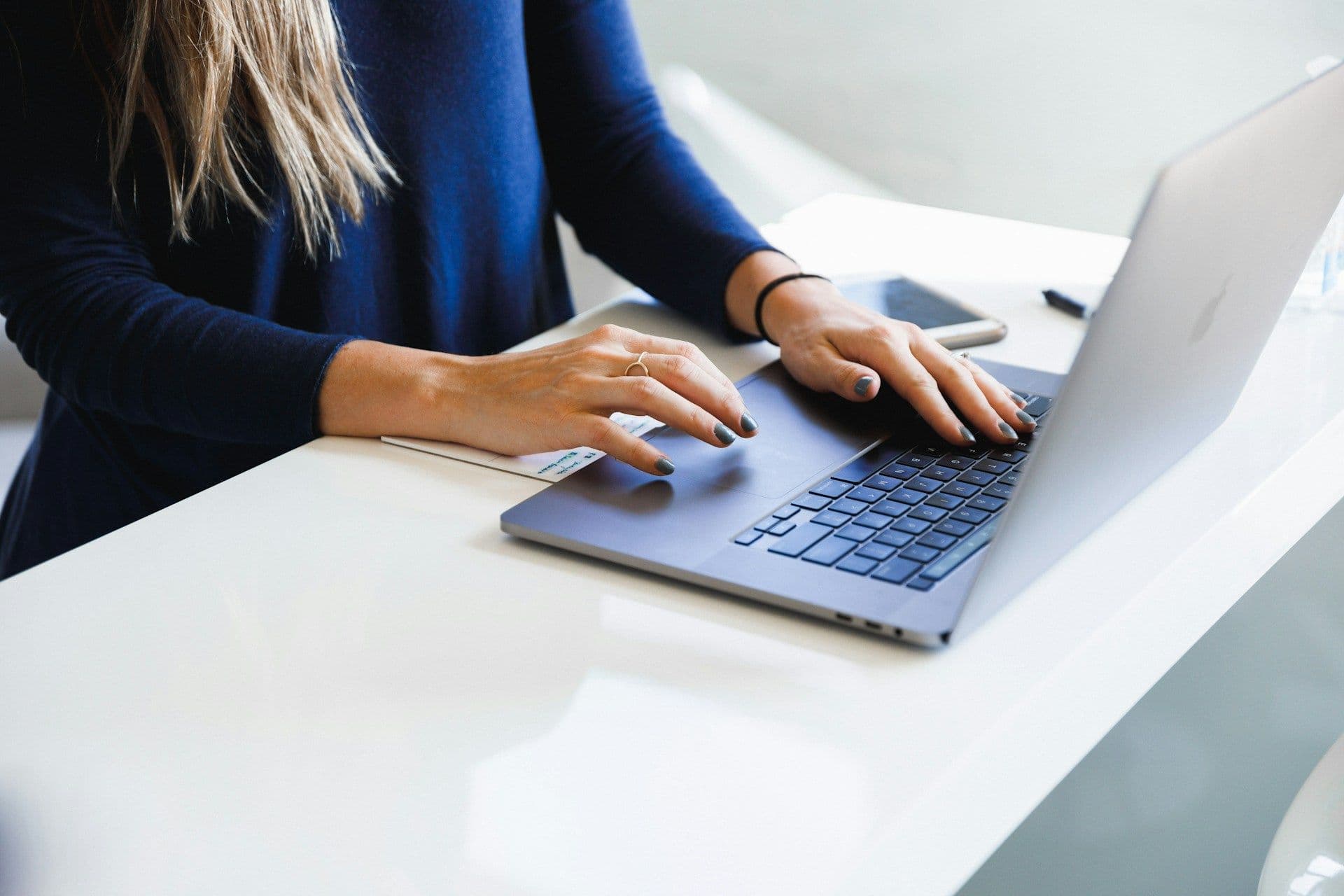 A person working on a laptop at a desk